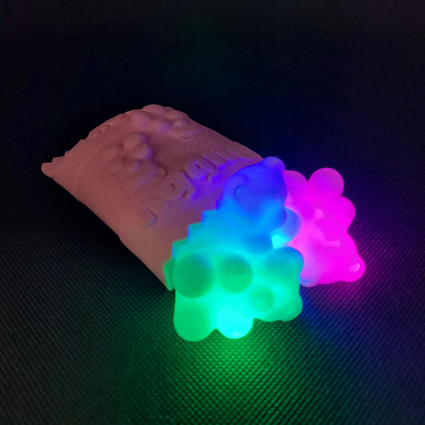 Untitled Small 3D printed light made to look like a spilled bag of gummy bears. Each gummy bear is illuminated from the inside with a different color light. There are three gummy bears: green, blue, magenta.